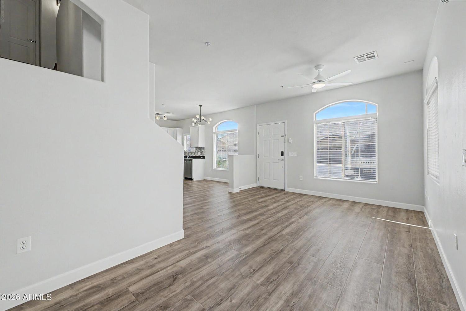 Living room with wood-look flooring and tall ceilings