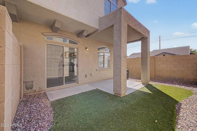 Covered patio with turf yard behind the townhome