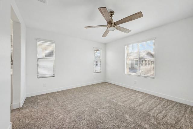 Primary bedroom with two windows and a ceiling fan