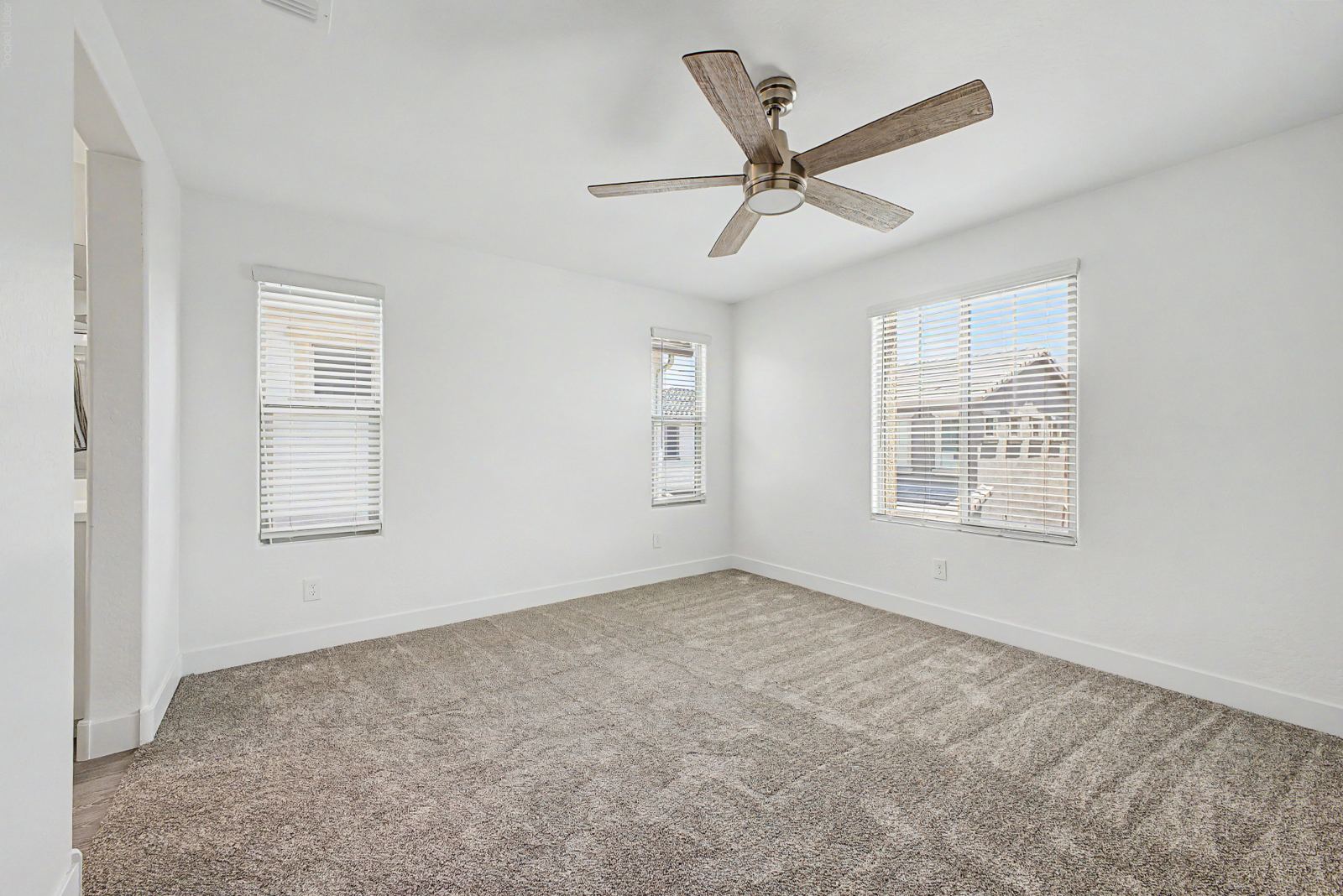 Primary bedroom with two windows and a ceiling fan