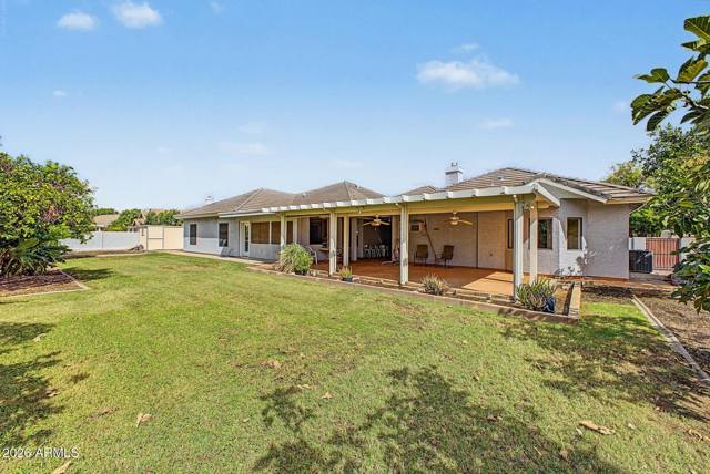 Wide view of the grassy backyard and covered patio