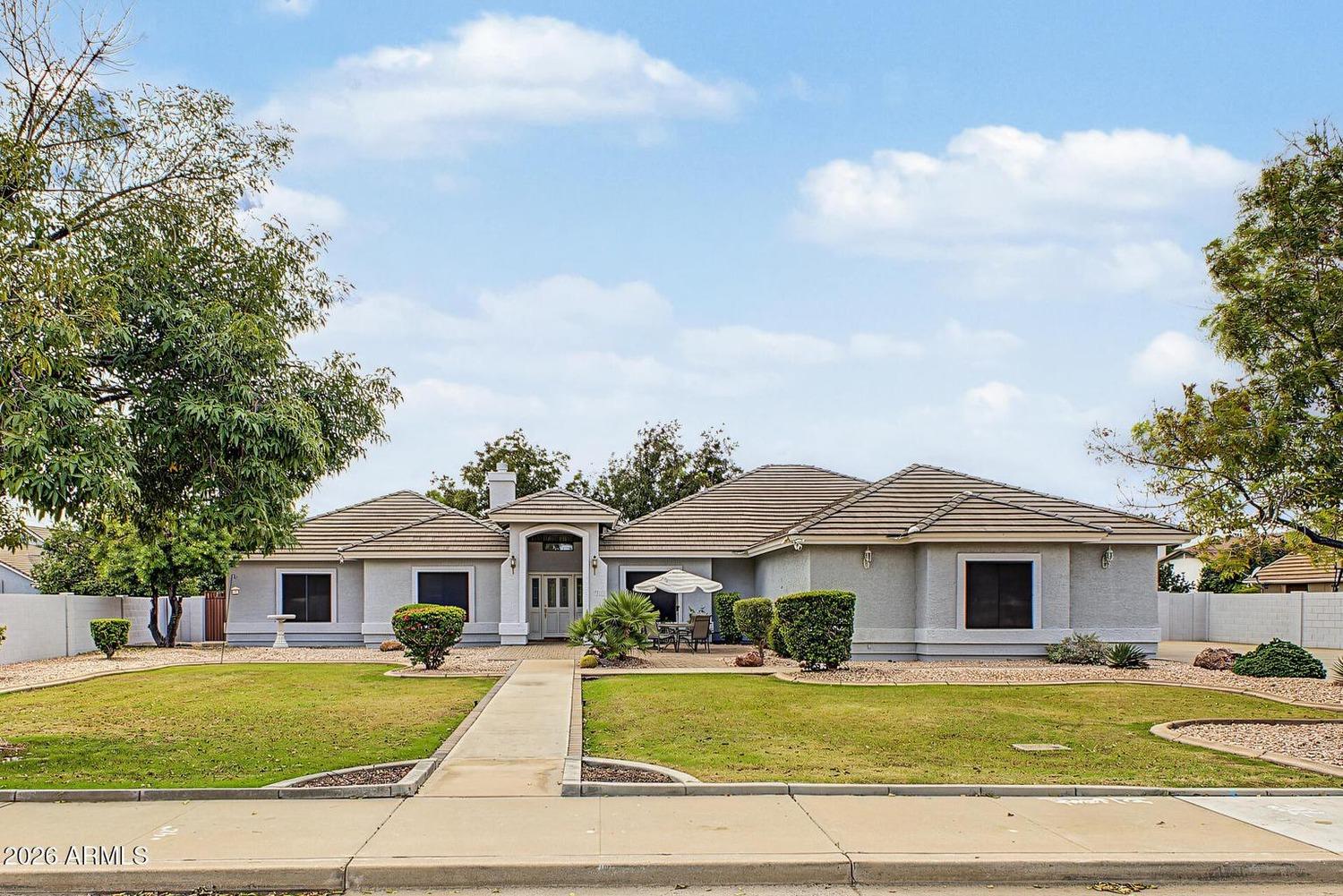Front exterior of 2711 E Pueblo Ave, a single-story home with a tile roof and green lawn