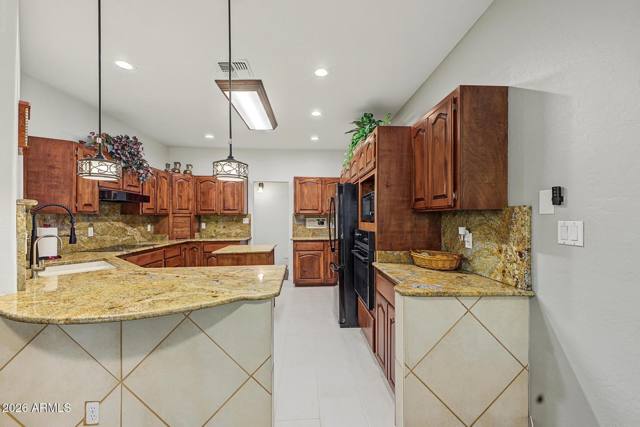 Kitchen with granite counters and wood cabinetry