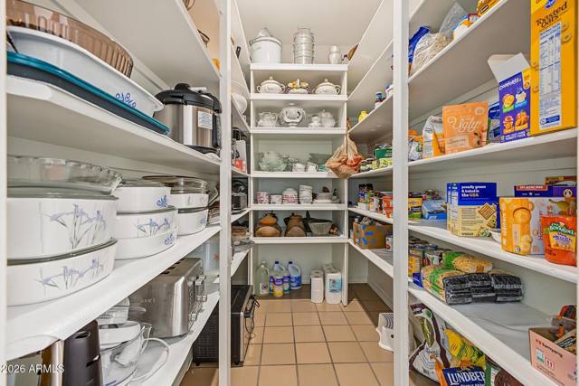 Walk-in pantry lined with white shelving