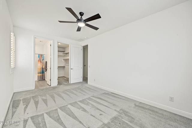Bedroom with doors open to an ensuite bathroom and walk-in closet