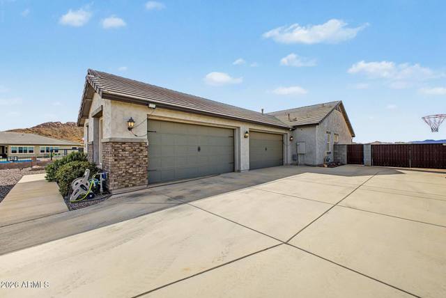 Four-car garage doors and wide concrete driveway