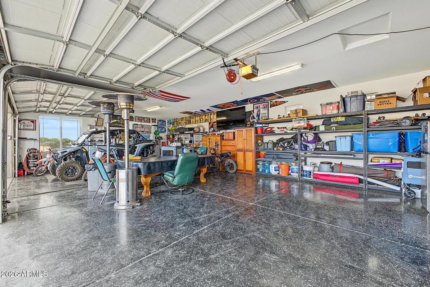 Interior of the four-car garage with epoxy floor, shelving and recreational vehicles