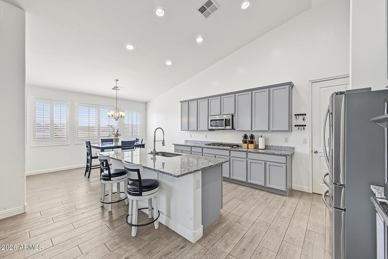 Kitchen with large granite island and grey cabinetry