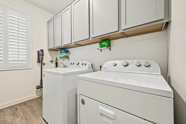 Laundry room with washer, dryer, utility sink and cabinets