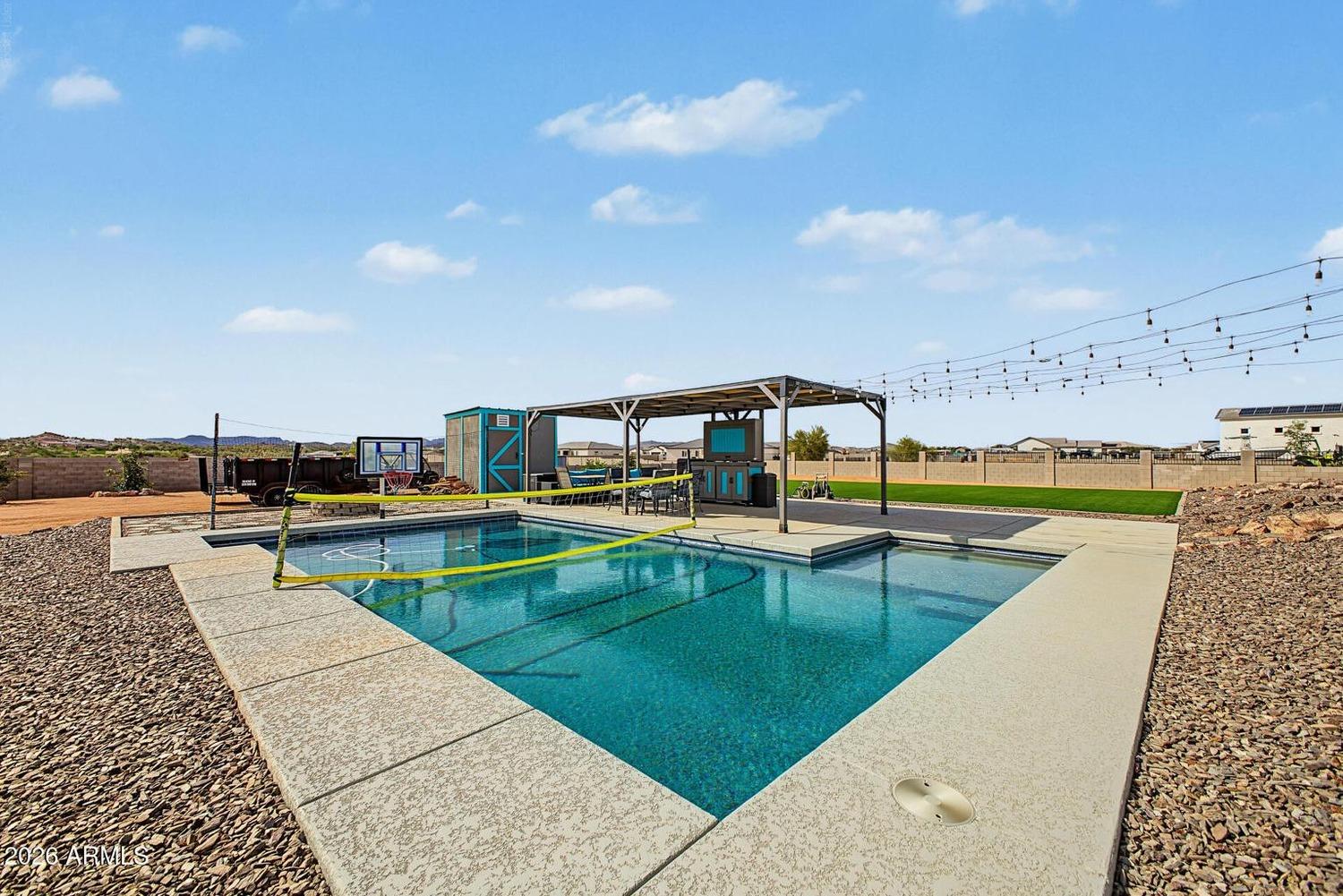Rectangular play pool with volleyball net and ramada beyond