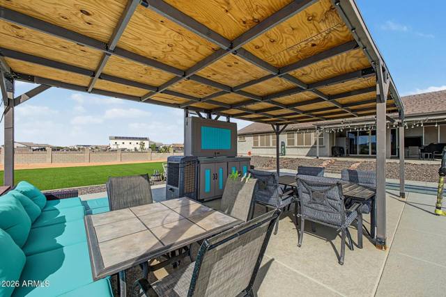Covered ramada with outdoor bar, dining table and lounge seating