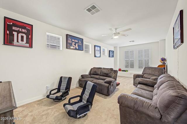 Large carpeted theatre room with recliners and wall-mounted television