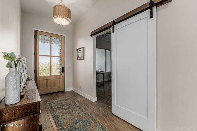 Front entry with wood door and sliding barn door to the office