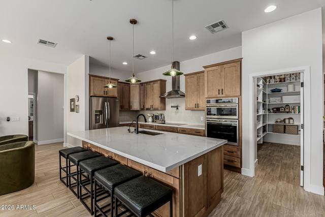 Wall oven, induction range and the walk-in pantry beyond