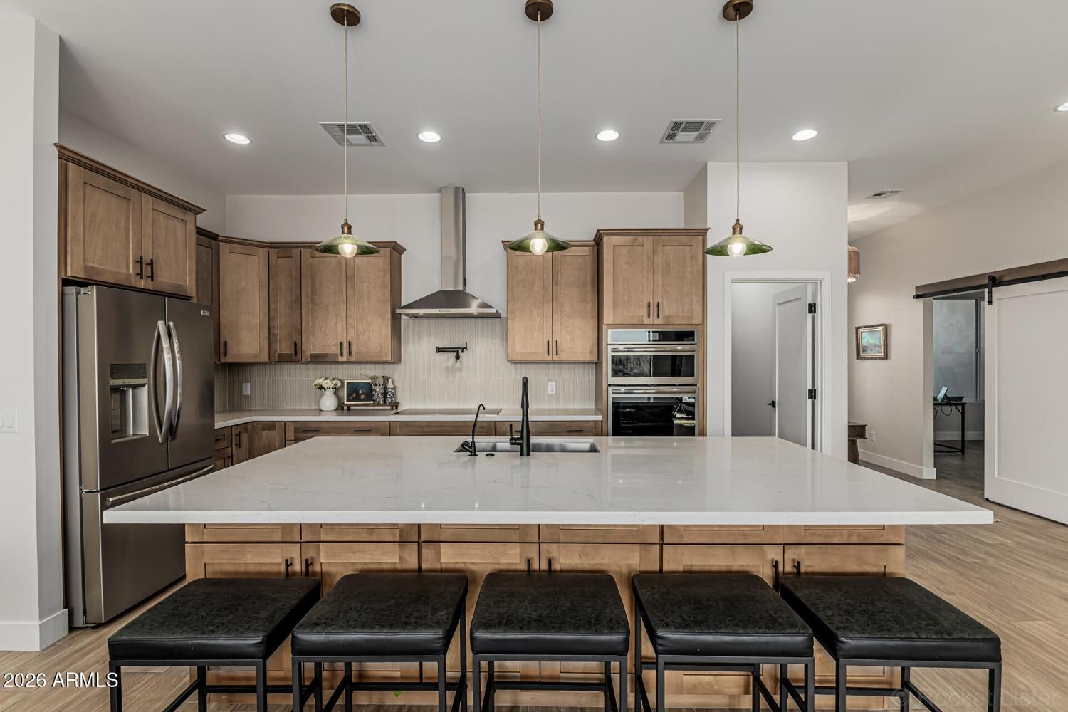 Kitchen with quartz counters, wood cabinetry and a large island